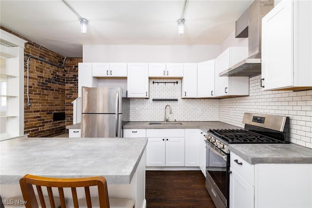 719 N 3rd St, Toronto, OH 43964 - kitchen with stainless steel appliances, wall chimney exhaust hood, white cabinetry, backsplash, and a peninsula