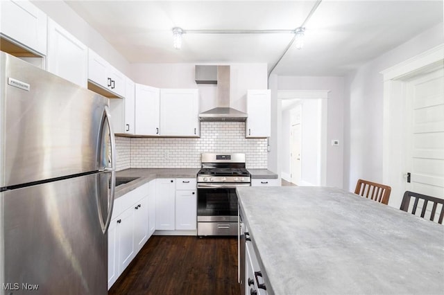 719 N 3rd St, Toronto, OH 43964 - kitchen with stainless steel appliances, wall chimney exhaust hood, backsplash, white cabinetry, and dark wood-type flooring