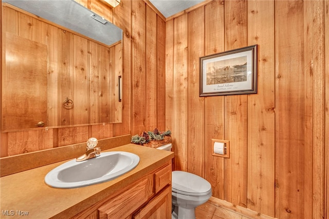12938 Carter Rd, Leroy, OH 44077 - half bath featuring vanity, wooden walls, and tile patterned floors