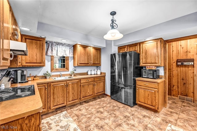 12938 Carter Rd, Leroy, OH 44077 - kitchen with freestanding refrigerator, exhaust hood, stovetop with downdraft, light countertops, and brown cabinetry