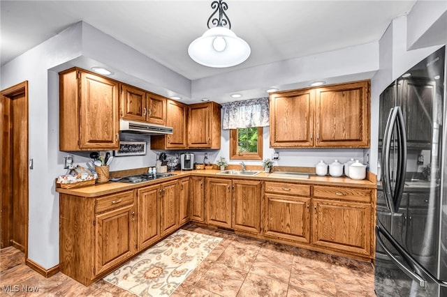 12938 Carter Rd, Leroy, OH 44077 - kitchen featuring black appliances, under cabinet range hood, brown cabinetry, light countertops, and decorative light fixtures