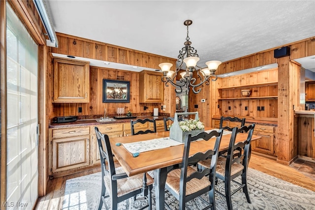 12938 Carter Rd, Leroy, OH 44077 - dining room featuring wooden walls, a chandelier, and light wood finished floors