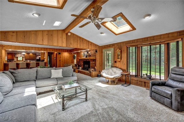 12938 Carter Rd, Leroy, OH 44077 - living area with a skylight, wood walls, a ceiling fan, carpet flooring, and a fireplace