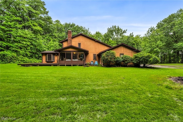 12938 Carter Rd, Leroy, OH 44077 - back of house with a sunroom, a chimney, and a lawn