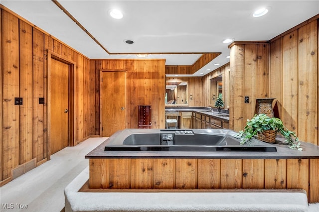 12938 Carter Rd, Leroy, OH 44077 - kitchen with brown cabinetry, wooden walls, a peninsula, and recessed lighting
