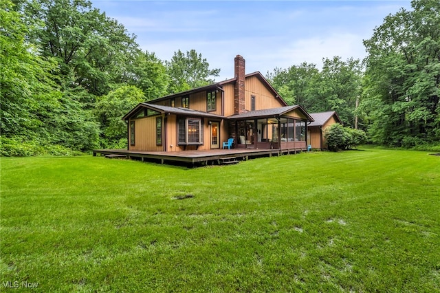 12938 Carter Rd, Leroy, OH 44077 - back of property featuring a chimney, a lawn, a wooden deck, and a sunroom