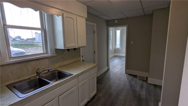 1111 2nd St NW, Canton, OH 44703 - kitchen featuring a paneled ceiling, white cabinetry, dark wood-type flooring, and light countertops