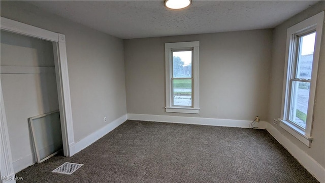 1111 2nd St NW, Canton, OH 44703 - unfurnished bedroom featuring dark colored carpet and a textured ceiling
