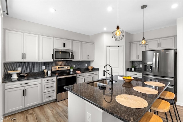 23563 Rebecca Ln, Columbia Station, OH 44028 - kitchen featuring stainless steel appliances, light wood-type flooring, a kitchen bar, backsplash, and hanging light fixtures