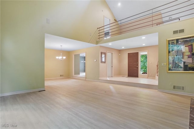 80 Hawthorne Ave, Rittman, OH 44270 - unfurnished living room featuring a chandelier, wood finished floors, a towering ceiling, and recessed lighting