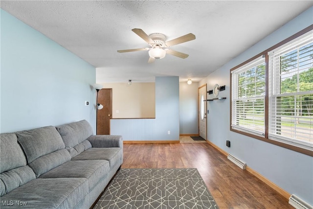 8132 Arlington Ave NW, North Canton, OH 44720 - living area featuring baseboard heating, wood finished floors, and ceiling fan
