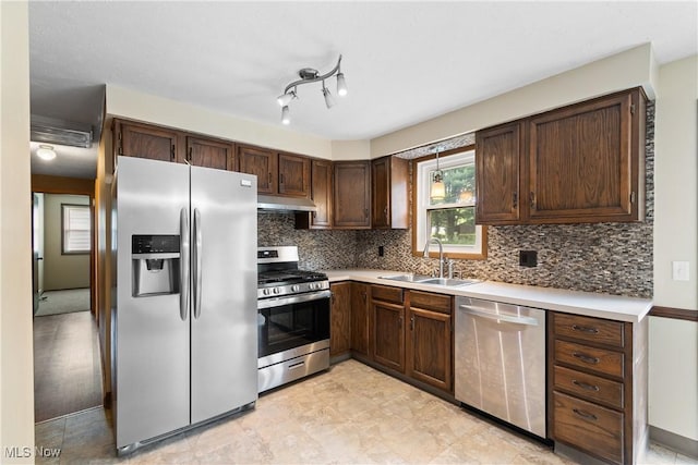 8132 Arlington Ave NW, North Canton, OH 44720 - kitchen featuring appliances with stainless steel finishes, under cabinet range hood, dark brown cabinetry, decorative backsplash, and light countertops