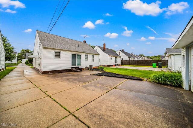24270 Glenforest Rd, Euclid, OH 44123 - back of house featuring entry steps, a patio area, a shingled roof, and a residential view