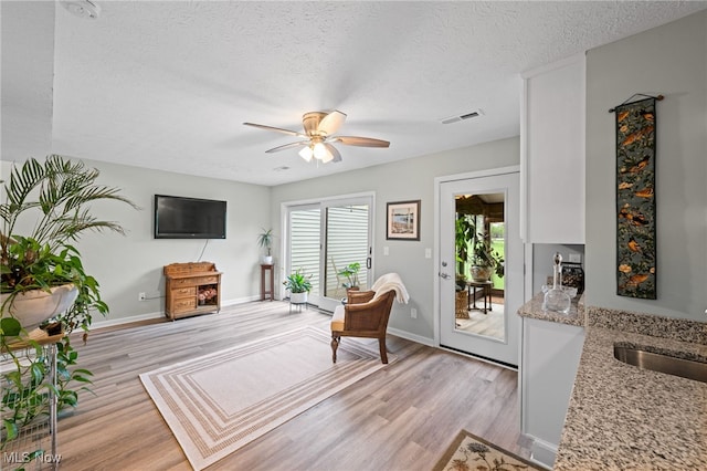 7152 Rippling Brook Ln, Concord, OH 44060 - living area with light wood finished floors, a textured ceiling, and ceiling fan