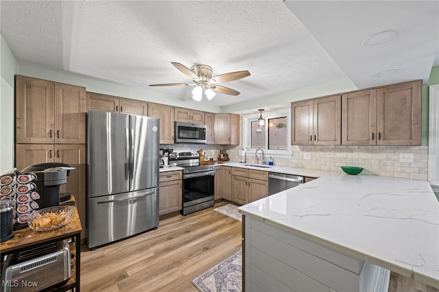 7152 Rippling Brook Ln, Concord, OH 44060 - kitchen with appliances with stainless steel finishes, a peninsula, ceiling fan, a textured ceiling, and light wood-type flooring
