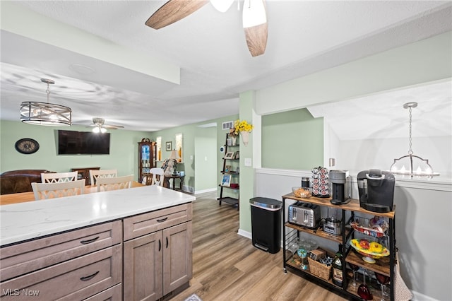 7152 Rippling Brook Ln, Concord, OH 44060 - kitchen featuring ceiling fan, light wood-style flooring, decorative light fixtures, light countertops, and a chandelier