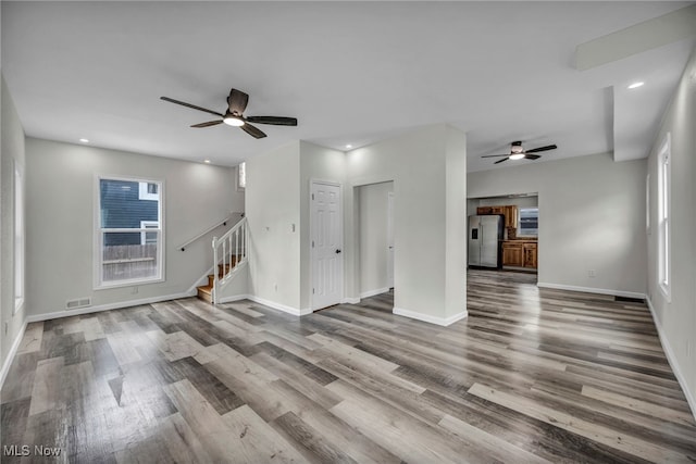 397 Furnace Rd, Conneaut, OH 44030 - unfurnished living room featuring a ceiling fan, wood finished floors, stairs, and recessed lighting