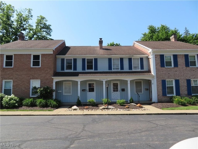 1609 S Main St Unit 22C, North Canton, OH 44709 - townhome / multi-family property featuring a chimney, board and batten siding, covered porch, and brick siding