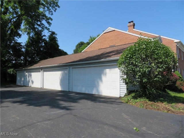 1609 S Main St Unit 22C, North Canton, OH 44709 - view of home's exterior with a chimney, a garage, and driveway