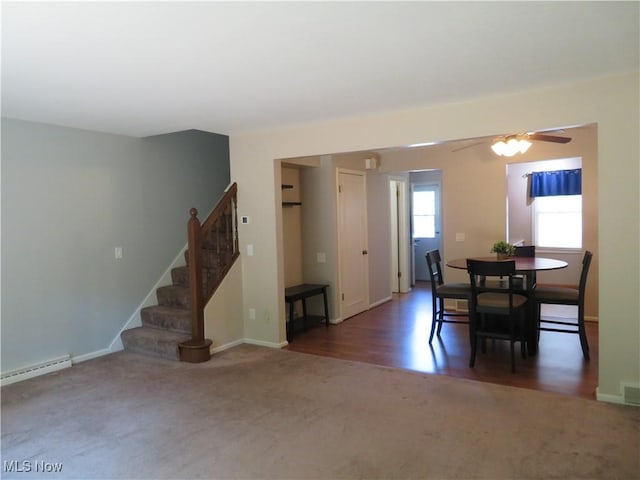 1609 S Main St Unit 22C, North Canton, OH 44709 - dining room with baseboard heating, carpet flooring, stairway, ceiling fan, and wood finished floors