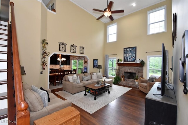8025 Wadsworth Rd, Wadsworth, OH 44281 - living room featuring a ceiling fan, crown molding, a stone fireplace, dark wood-style floors, and a towering ceiling