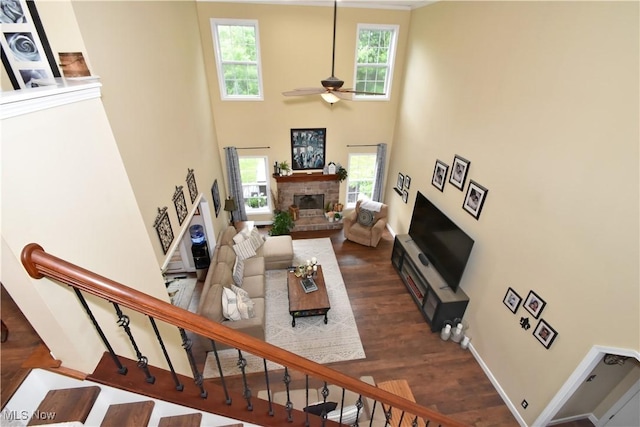 8025 Wadsworth Rd, Wadsworth, OH 44281 - living room with a fireplace, a ceiling fan, a high ceiling, wood finished floors, and stairs