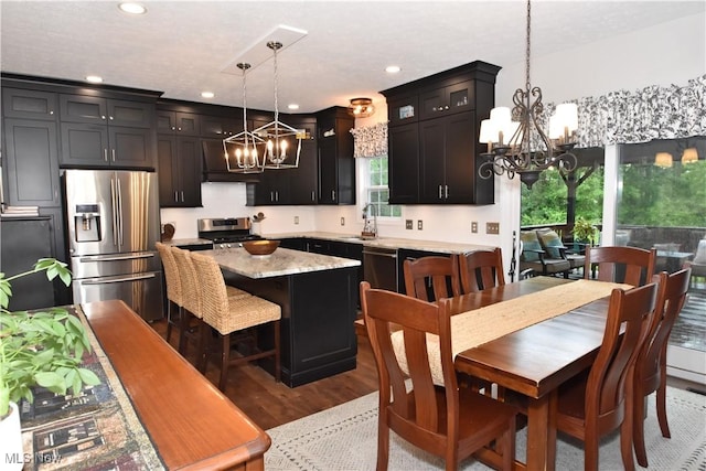 8025 Wadsworth Rd, Wadsworth, OH 44281 - kitchen with a chandelier, appliances with stainless steel finishes, wood finished floors, recessed lighting, and glass insert cabinets