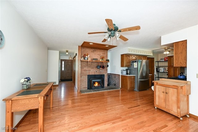 6111 State Route 82, Hiram, OH 44234 - living area featuring a ceiling fan, light wood-type flooring, and a brick fireplace