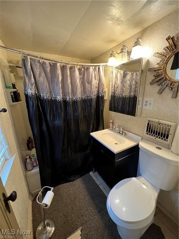629 Willard Ave SE, Warren, OH 44483 - full bathroom with vanity, a shower with curtain, and tile patterned flooring