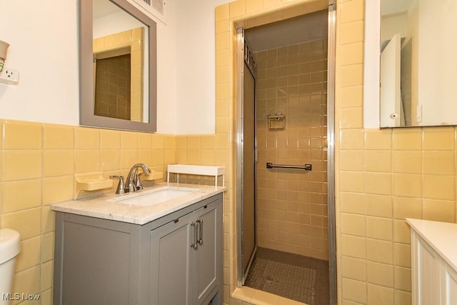 13800 Fairhill Rd Unit 206, Shaker Heights, OH 44120 - bathroom featuring tile walls, vanity, a stall shower, and a wainscoted wall