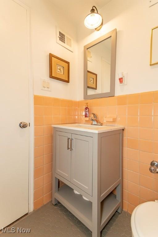 13800 Fairhill Rd Unit 206, Shaker Heights, OH 44120 - bathroom with tile walls, tile patterned floors, vanity, and wainscoting