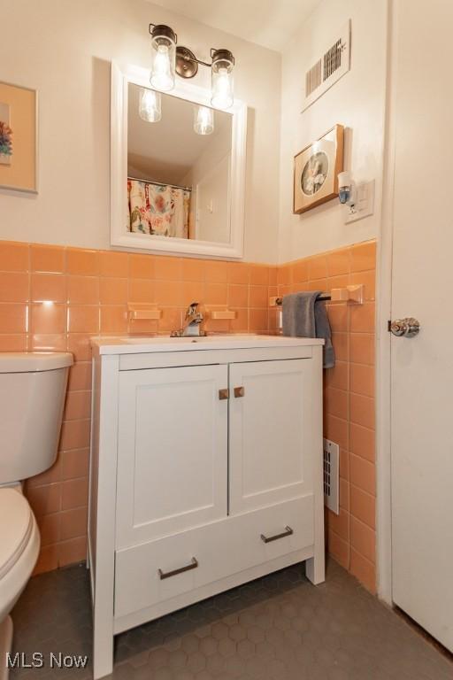 13800 Fairhill Rd Unit 206, Shaker Heights, OH 44120 - full bathroom with tile walls, tile patterned floors, vanity, and wainscoting