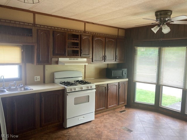 129 Bennett, Vienna, OH 44473 - kitchen with gas range gas stove, under cabinet range hood, black microwave, ceiling fan, and light countertops