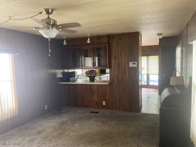 129 Bennett, Vienna, OH 44473 - kitchen with a ceiling fan, a textured ceiling, carpet flooring, wood walls, and light countertops