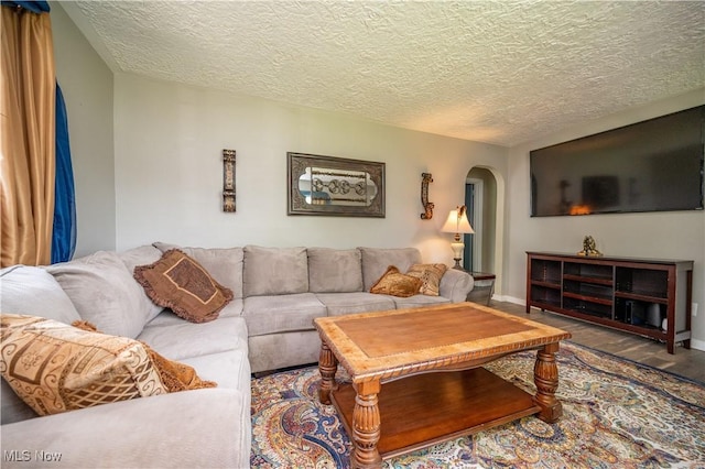1432 Maxwell Ave NW, Warren, OH 44485 - living area featuring arched walkways, wood finished floors, and a textured ceiling
