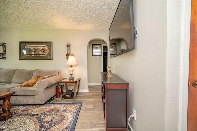 1432 Maxwell Ave NW, Warren, OH 44485 - living area with arched walkways, wood finished floors, and a textured ceiling