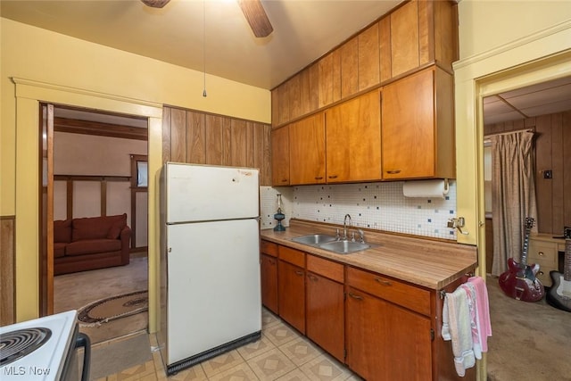 11604 Thornwood Ave, Cleveland, OH 44108 - kitchen featuring freestanding refrigerator, stove, brown cabinets, and ceiling fan