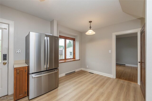 36 Rosedale Blvd, Norwalk, OH 44857 - kitchen featuring freestanding refrigerator, brown cabinets, light wood finished floors, decorative light fixtures, and light countertops