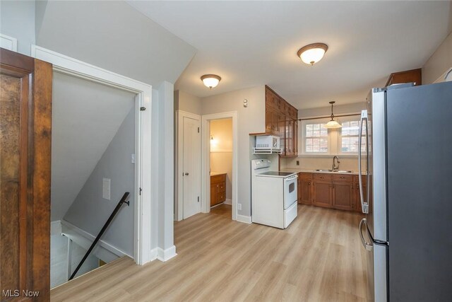 36 Rosedale Blvd, Norwalk, OH 44857 - kitchen with white appliances, light wood-style floors, brown cabinetry, pendant lighting, and light countertops