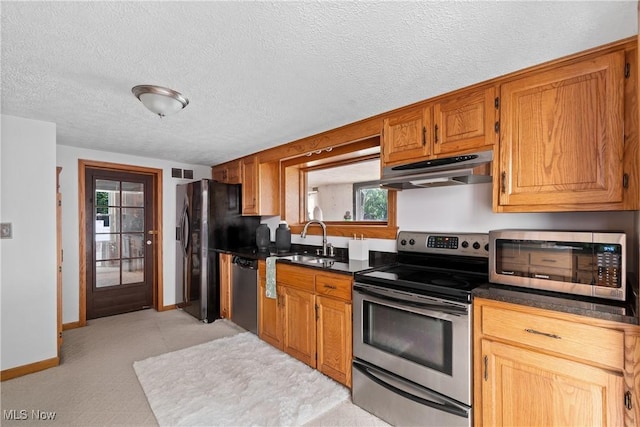 3568 Peninsula Dr, Coventry, OH 44319 - kitchen with appliances with stainless steel finishes, under cabinet range hood, dark countertops, a textured ceiling, and brown cabinets