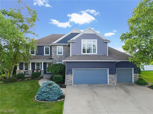 905 Braemar Cir, North Canton, OH 44720 - craftsman-style house featuring stone siding, concrete driveway, a front yard, and a garage
