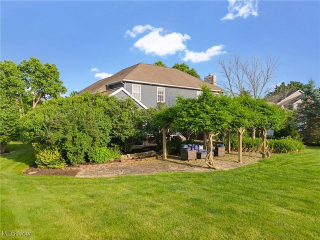 905 Braemar Cir, North Canton, OH 44720 - rear view of property featuring a lawn, a chimney, and an outdoor hangout area