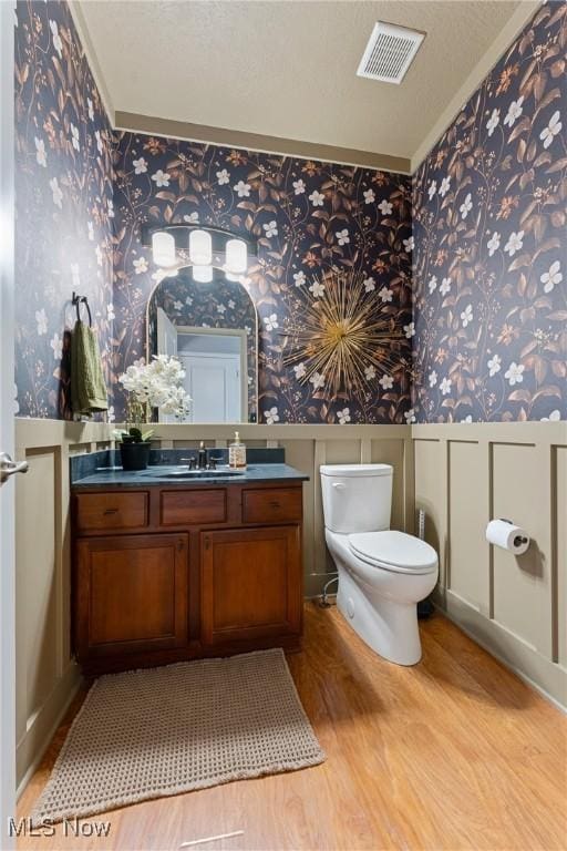 905 Braemar Cir, North Canton, OH 44720 - bathroom featuring wallpapered walls, wainscoting, wood finished floors, vanity, and crown molding