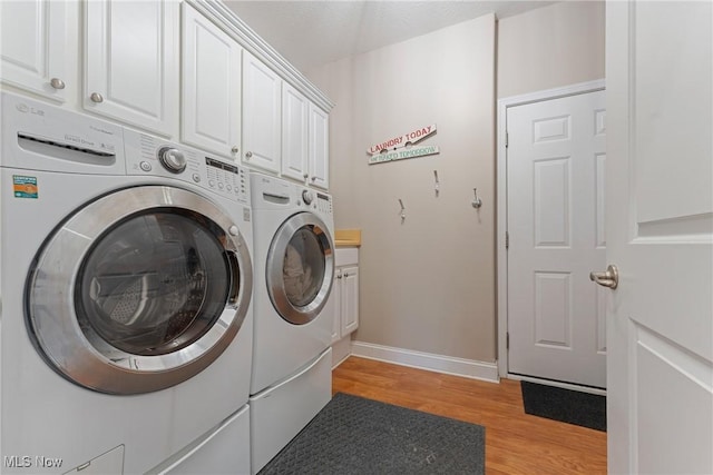 905 Braemar Cir, North Canton, OH 44720 - washroom featuring independent washer and dryer, light wood-style floors, and cabinet space