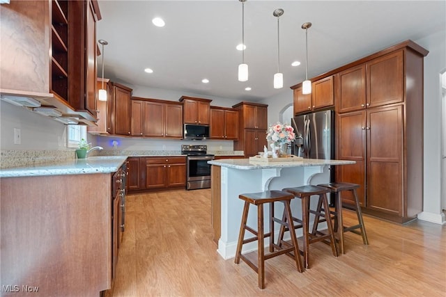 905 Braemar Cir, North Canton, OH 44720 - kitchen featuring stainless steel appliances, light wood-type flooring, brown cabinets, a breakfast bar, and recessed lighting