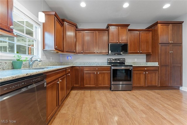 905 Braemar Cir, North Canton, OH 44720 - kitchen with stainless steel appliances, light wood-style floors, brown cabinets, recessed lighting, and light stone countertops