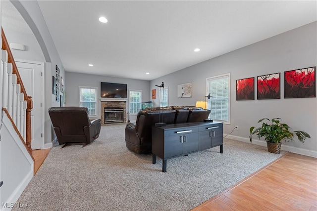 905 Braemar Cir, North Canton, OH 44720 - living room with stairs, a fireplace, recessed lighting, light wood-type flooring, and arched walkways