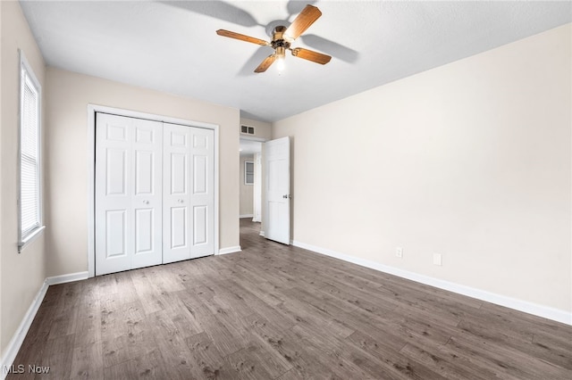 907 Hillsdale Ave, Parma, OH 44134 - unfurnished bedroom with wood finished floors, a closet, and multiple windows