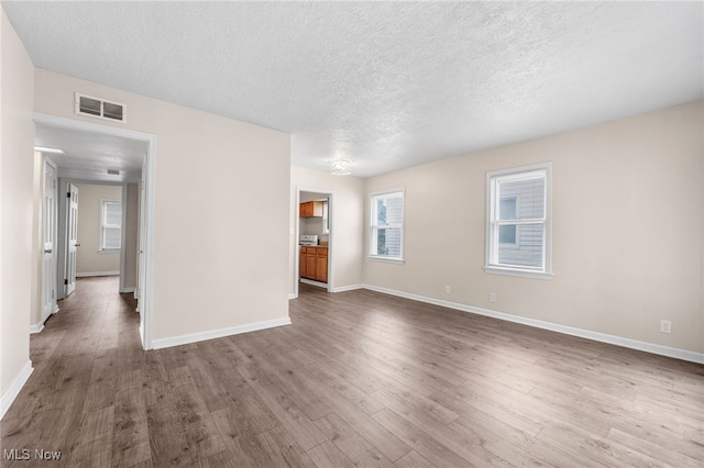 907 Hillsdale Ave, Parma, OH 44134 - unfurnished living room featuring wood finished floors and a textured ceiling