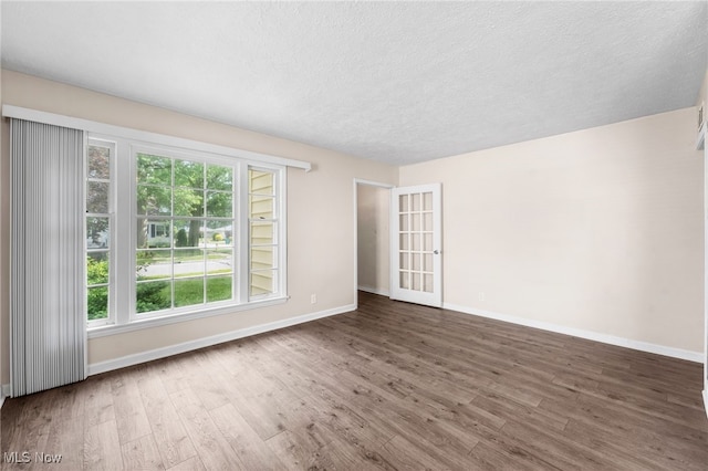 907 Hillsdale Ave, Parma, OH 44134 - empty room with wood finished floors, healthy amount of natural light, and a textured ceiling